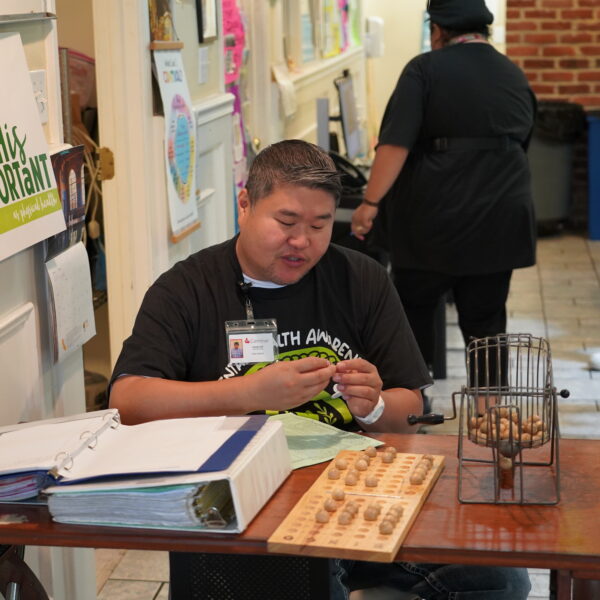 A Caminar staff member reads out numbers during a bingo game.