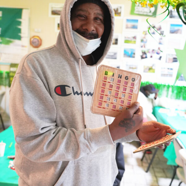 A guest at the Wellness and Recovery center holds up a winning bingo card.
