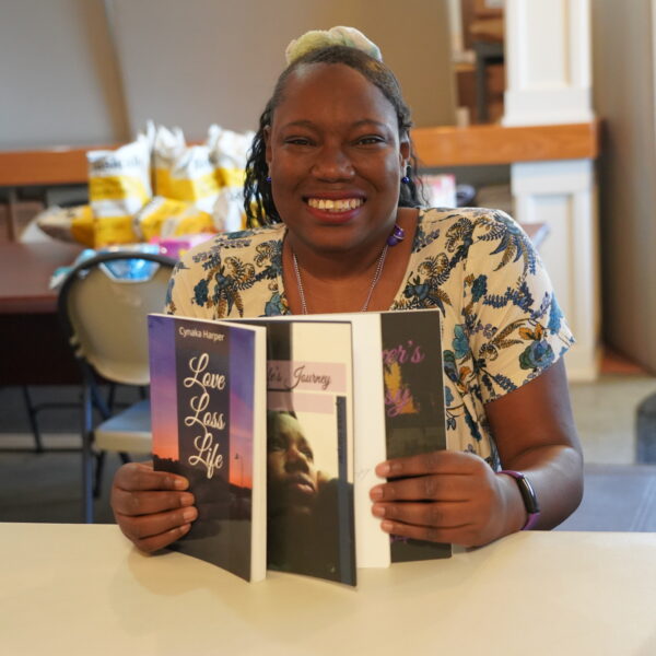 A woman displays two of her poetry books.