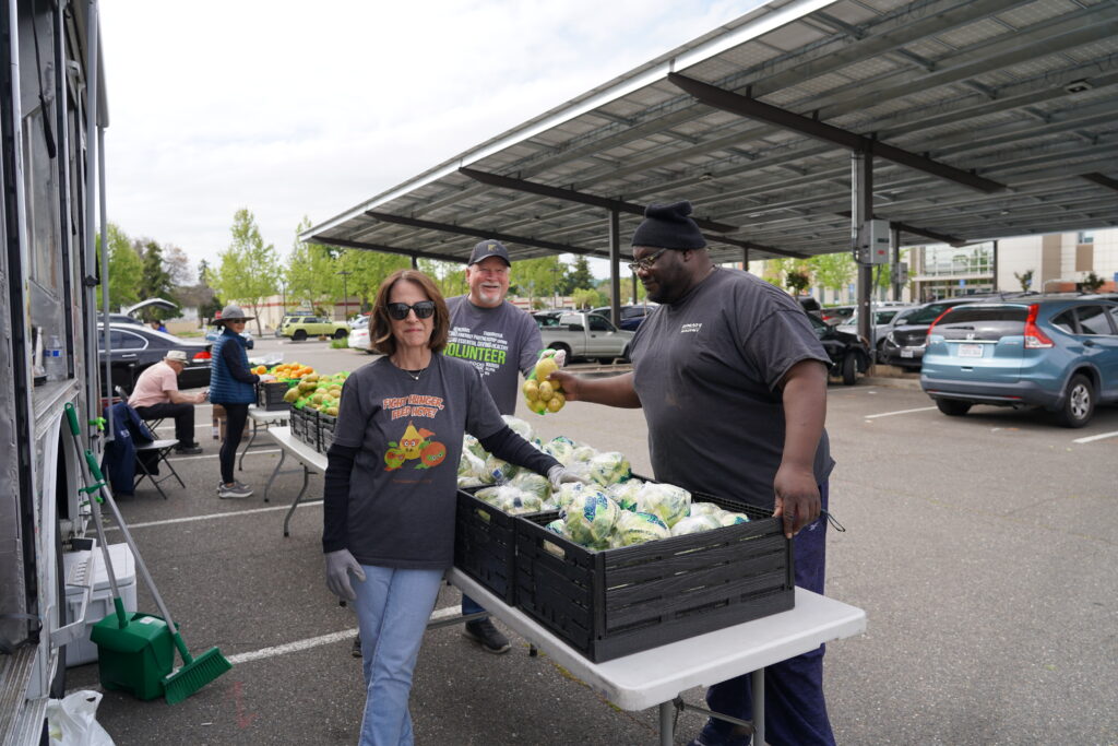 Volunteers pose with a client at our Mobile Food Pharmacy.