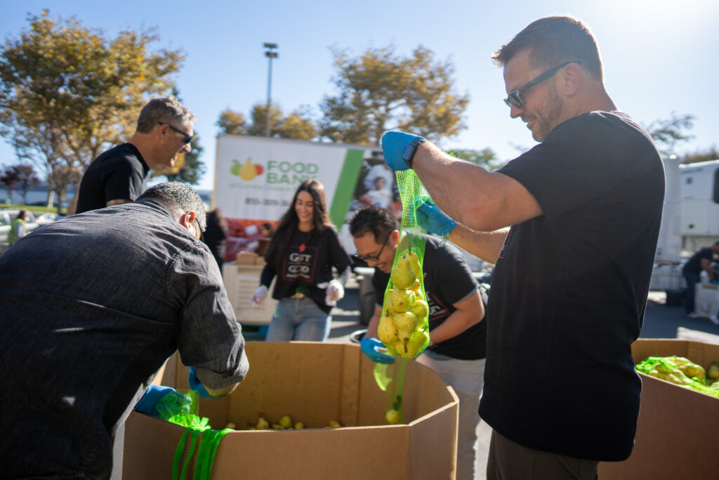 A volunteer bags produce at a remote team building volunteer opportunity.